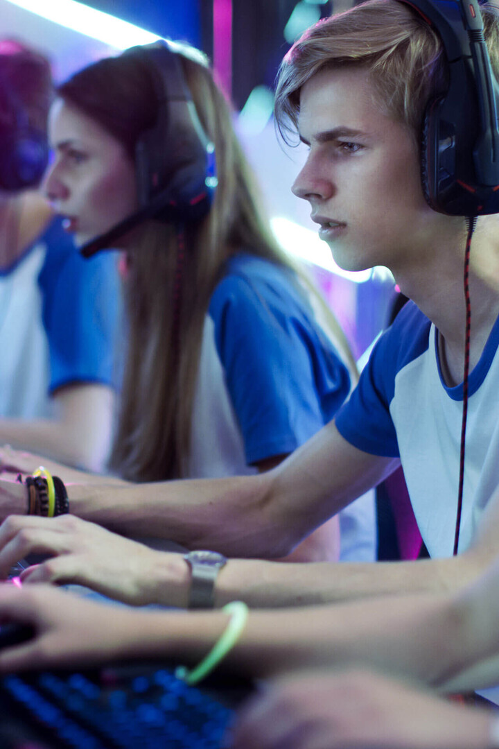 Junger E-Sport-Spieler mit Headset konzentriert vor dem Computer